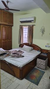 a bedroom with a bed and a window at Gem Backpackers Hostel in Siliguri +3 photos