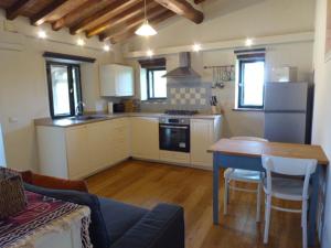 a kitchen with a table and a kitchen with a refrigerator at Studio in Tuscan farmhouse with pool in Monteguidi +21 photos