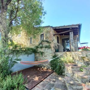 a hammock hanging outside of a stone house at Studio in Tuscan farmhouse with pool in Monteguidi