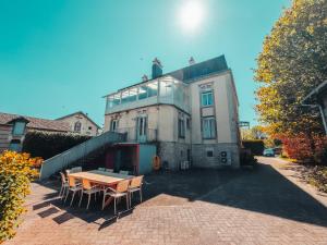 a house with a table and chairs in front of it at La Canopée in Verdun-sur-Meuse