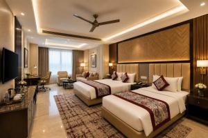 a hotel room with two beds and a television at Hotel Luxury Stay Igi Airport Delhi in New Delhi