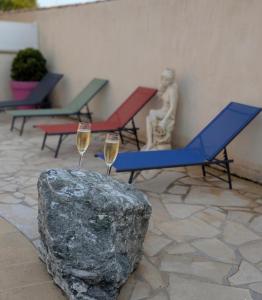 a couple of glasses of wine next to a rock at Le Jasmin in Mauguio