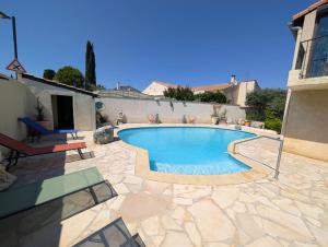 a swimming pool in a yard with a house at Le Jasmin in Mauguio