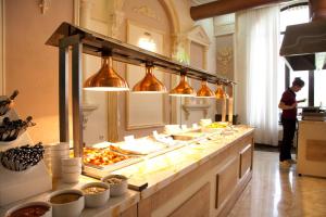 a man standing in front of a buffet line with food at Borjomind Hotel Borjomi in Borjomi
