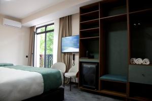 a hotel room with a bed and a tv at Borjomind Hotel Borjomi in Borjomi