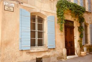 a building with blue shutters and a door at Le Bel Angle in Arles +21 photos