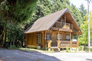 a large wooden cabin with a porch and a balcony at Mtd大分天ヶ瀬 in Hita