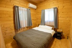 a bedroom with a bed in a wooden room at Mtd大分天ヶ瀬 in Hita