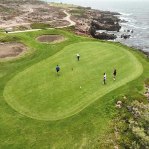 a group of people playing golf on a golf course at Campo Rivera Beach Community in La Misión