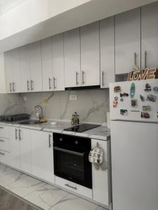 a kitchen with white cabinets and a refrigerator at Flat in Trpejca in Ohrid