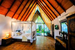 a bedroom with a bed and a large window at Taro River Resort Negombo in Otarawadiya +43 photos