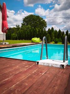 a pool with a wooden deck and a swimming pool at Peščani breg in Banatski Karlovac