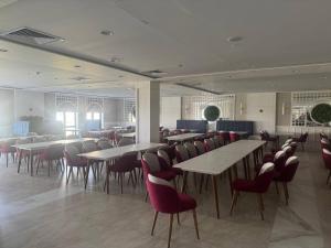 a dining room with tables and red chairs at Imam Bukhari Grand Hotel in Khodzha-Ismail