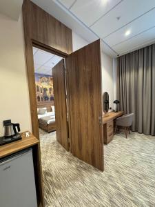 a hotel room with a door leading to a bedroom at Imam Bukhari Grand Hotel in Khodzha-Ismail