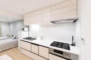 a white kitchen with a sink and a stove at Room 501 Japanese Tatami 3LDK 75sqm Near Namba Family Friendly Stay in Osaka +32 photos