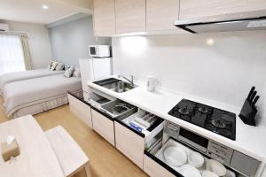 a small kitchen with a stove and a bed at Room 501 Japanese Tatami 3LDK 75sqm Near Namba Family Friendly Stay in Osaka