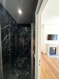 a bathroom with a shower with black marble at Le Clos Langevin in Épernay +39 photos