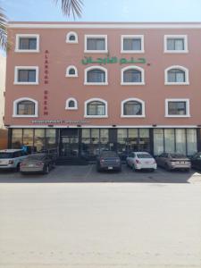 a pink building with cars parked in front of it at Alarjan Dream in Riyadh
