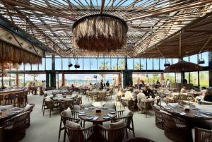 a restaurant with tables and chairs and people sitting at them at Inter Home Coral - beach access in Ras al Khaimah