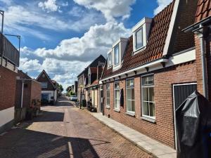 an empty street with brick houses and a blue sky at Oude Dorp Zicht in Urk
