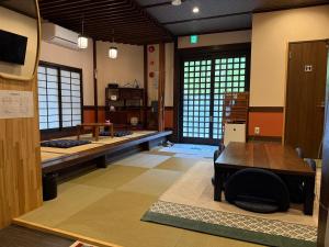 a room with a desk and a table and chairs at 民泊利休 in Sakai