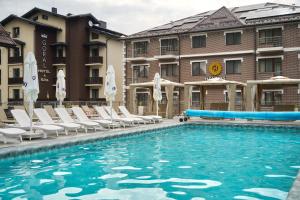 a swimming pool with lounge chairs and a hotel at Goral Hotel & Spa in Bukovel