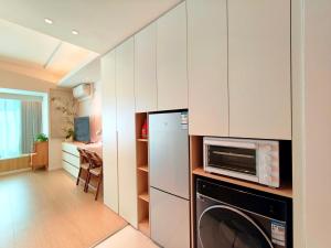 a kitchen with a refrigerator and a washer and dryer at Shanghai Cosmo World Union Service Apartment in Shanghai