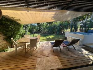 a wooden deck with a table and chairs on it at Cosy Studio 71 in Petite Case Noyale +5 photos