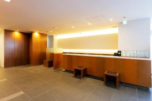 a waiting room with a counter and two stools at JR Inn Sapporo in Sapporo
