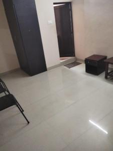 a room with a chair and a table and a door at Royal Residency in Gingee