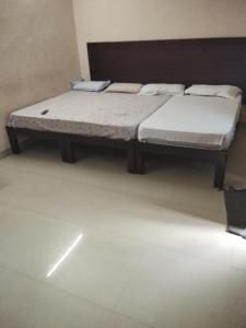 two beds sitting in a room with at Royal Residency in Gingee