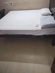 a bed with white sheets and towels on it at Royal Residency in Gingee