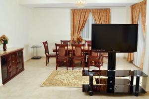 a living room with a large flat screen tv at Sara Hotel Apartments in Ajman 