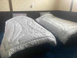 a white comforter on a bed in a room at Taisho Roman-style Private Villa with Original Japanese Art 日本画原画の一棟貸し M's Lumos in Marugame