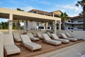 a group of lounge chairs on the deck of a house at Dennys Inn Hotel in Kalamaki