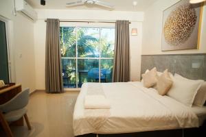 a bedroom with a bed and a large window at YUVi Blue Guesthouse at Himmafushi in Himmafushi