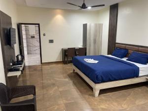 a bedroom with a bed with blue sheets and a table at SSR PARADISE ROOMs in Kavarapettai