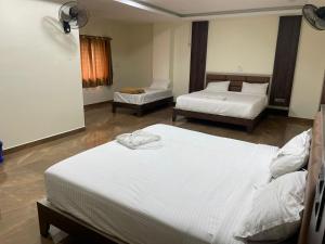 a hotel room with two beds in a room at SSR PARADISE ROOMs in Kavarapettai +13 photos