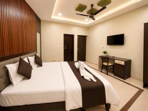a bedroom with a large bed and a desk at Hotel Balaji Inn in Raipur