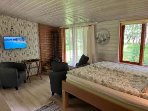 a bedroom with a bed and a tv on a wall at sun& relax- TINYHOUSE in Sõitme