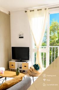 a living room with a tv and a large window at Natura2000 in Châteauroux