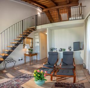 a living room with two chairs and a staircase at Eremo della Gasprina in La Morra