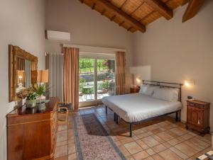 a bedroom with a bed and a desk and a window at Eremo della Gasprina in La Morra