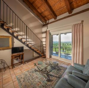 a living room with a staircase and a couch at Eremo della Gasprina in La Morra