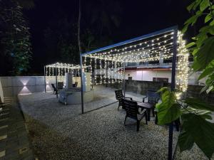 a patio with chairs and lights at night at Seabay Bliss Varkala by Ojes in Varkala