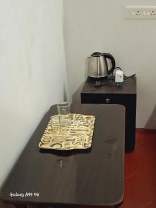 a black table with a glass on top of it at Umbrella Guest House - Palace Suite in Madurai