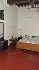 a bedroom with a bed and a mirror and a table at Umbrella Guest House - Palace Suite in Madurai
