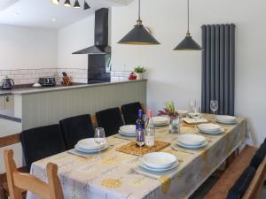 a dining room table with plates and wine glasses at Pantglas in Llandysul