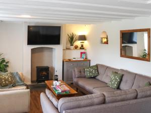 a living room with a couch and a fire place at Pantglas in Llandysul