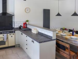 a kitchen with white cabinets and a counter top at Pantglas in Llandysul